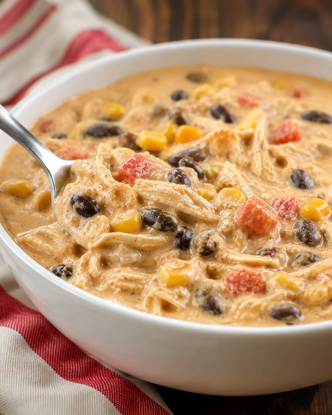 Hearty and creamy crock pot chicken chili with beans and cheese served in a white bowl