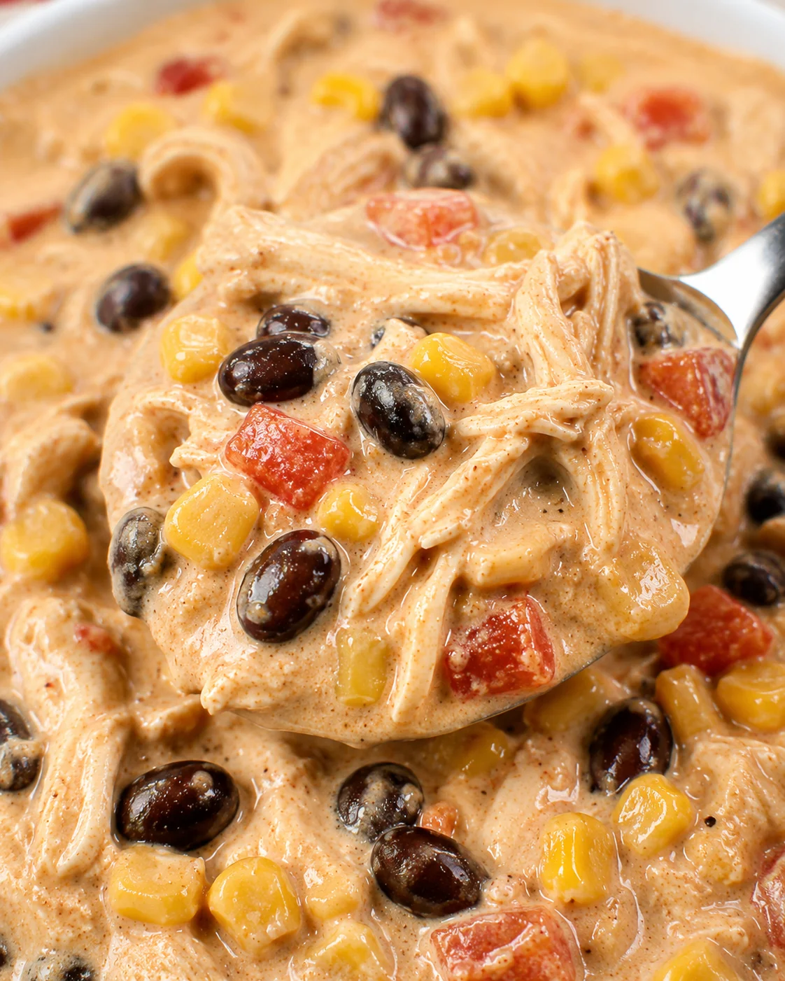 Creamy chicken chili with beans, corn, and melted cream cheese in a bowl