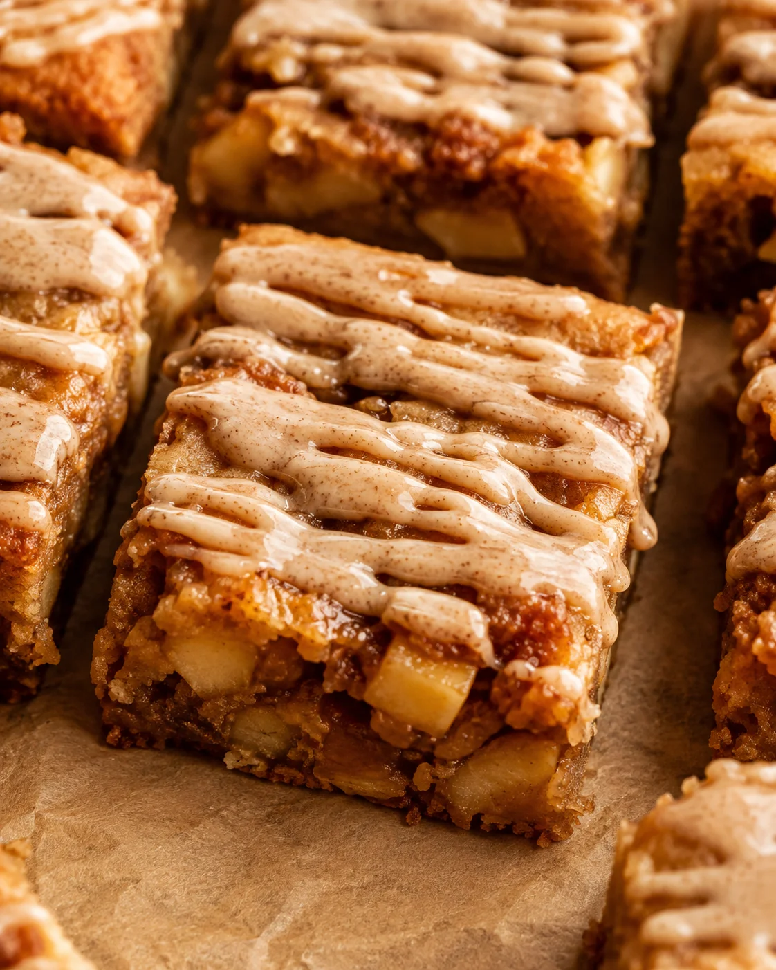 Close-up of apple blondies topped with cinnamon maple glaze, showcasing fall flavors