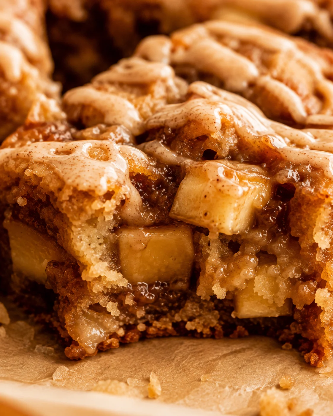 Close-up of gooey apple blondies topped with cinnamon maple glaze.
