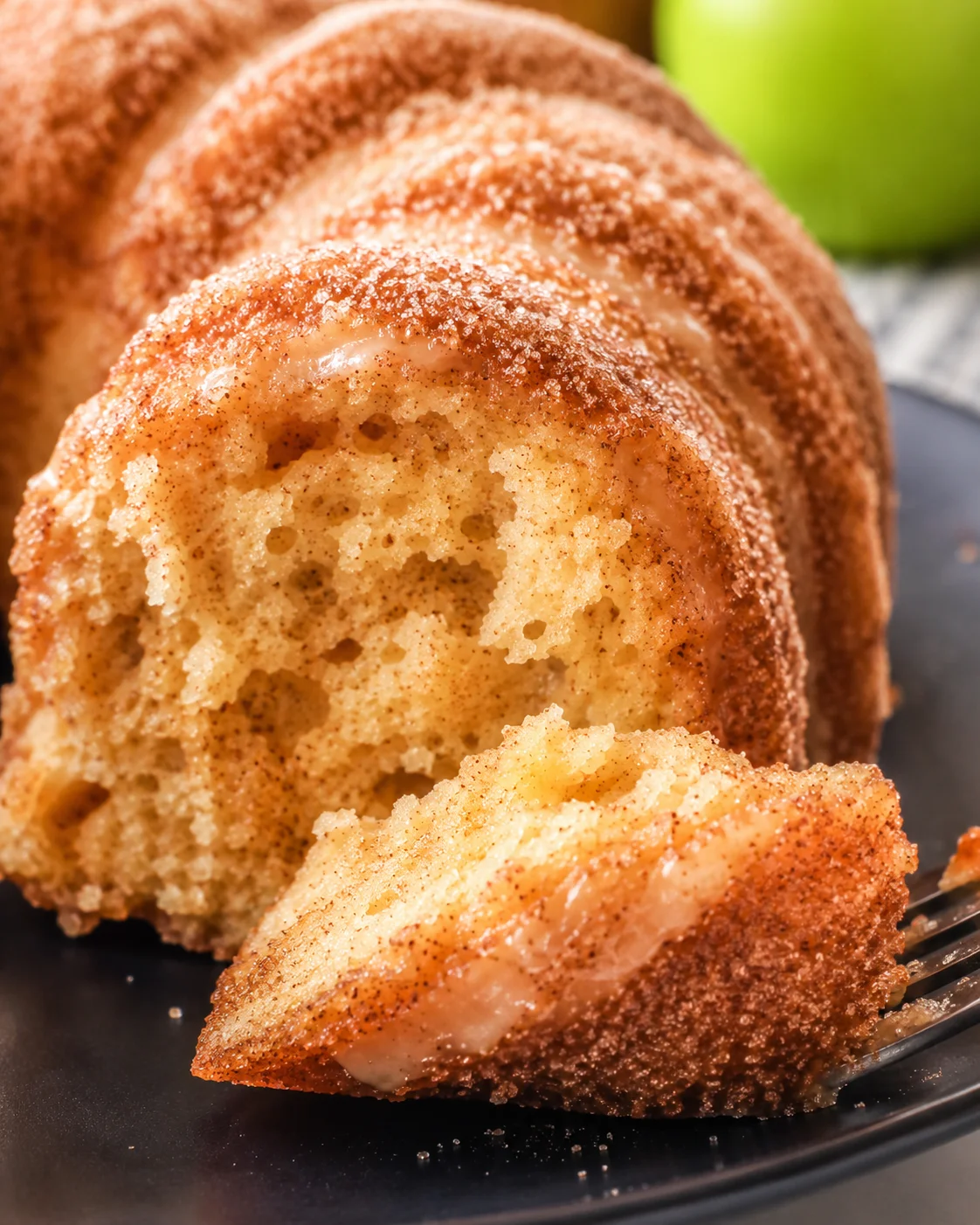 Close-up of a sliced apple cider donut cake with cinnamon sugar topping